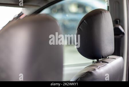 Der Fahrzeuginnenraum wird nach dem Unfall beschädigt, Glasscherben am Sitz. Beschädigter Fahrzeuginnenraum. Stockfoto