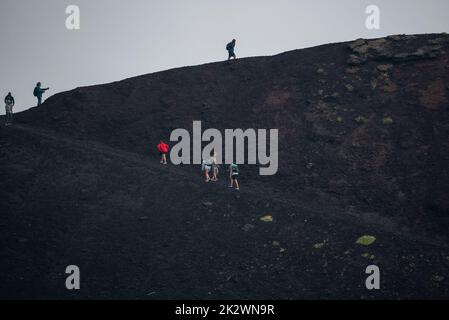 Touristen Trekking auf vulkanischen Ätna mit rauchigen Himmel im Hintergrund Stockfoto