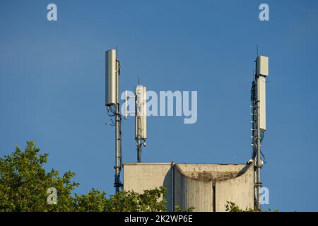 Nahaufnahme eines Antennenmastes für die Mobilfunkkommunikation vor blauem Himmel Stockfoto