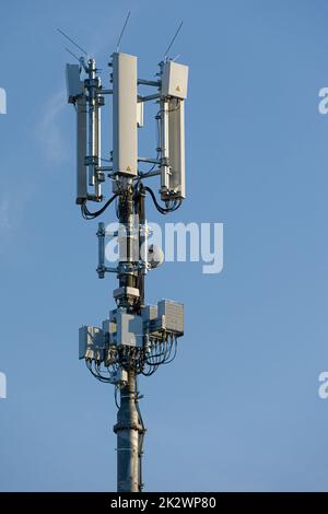 Nahaufnahme eines Antennenmastes für die Mobilfunkkommunikation vor blauem Himmel Stockfoto