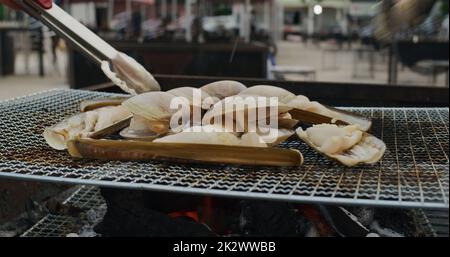 Frische, kurzhalsige Muschel und Razor Clam auf dem Grillnetz Stockfoto