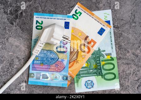 Weißer Elektrostecker auf Euro-Banknoten Stockfoto