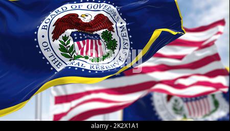 Die Flagge des amerikanischen Federal Reserve Systems, die im Wind winkt, mit der Flagge der Vereinigten Staaten im Hintergrund verschwommen Stockfoto