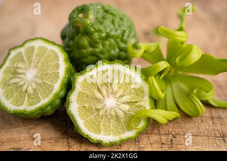 Frische Bergamotte Früchte mit in zwei Hälften geschnitten auf Holz Hintergrund. Stockfoto