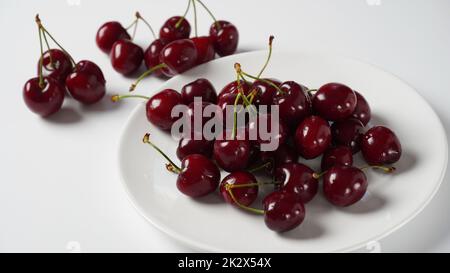 Süße rote Kirschen auf einem Teller, frische reife Sauerkirschen. Stockfoto