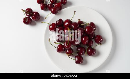 Süße rote Kirschen auf einem Teller, frische reife Sauerkirschen. Stockfoto