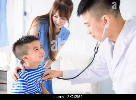 Männlicher Kinderarzt hält Stethoskop Untersuchung Kind Junge Patient besuchen Arzt mit Mutter Stockfoto