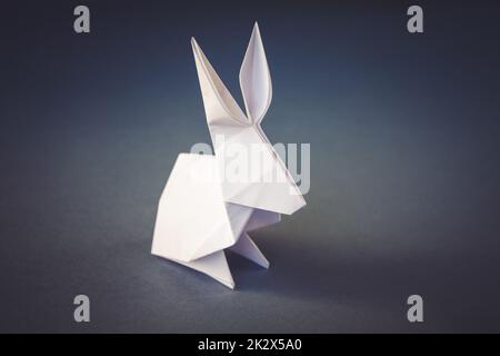 Weißes Papier Kaninchen Origami isoliert auf einem grauen Hintergrund Stockfoto