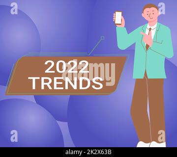 Handgeschriebenes Schild 2022 Trends. Ein Wort für Dinge, die im laufenden Jahr für kurze Zeit berühmt sind, man-Holding-Bildschirm des Mobiltelefons mit der futuristischen Technologie. Stockfoto