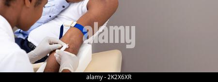 Arzt injizierenden Patienten mit Spritze zu sammeln Blut Stockfoto
