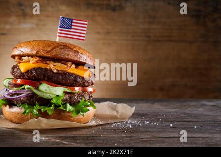 Burger mit amerikanischem Flaggenspieß auf dem Tisch Stockfoto