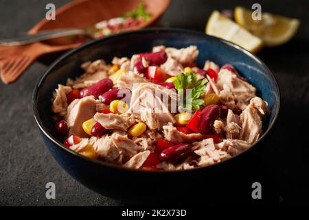 Schüssel mit köstlichem Thunfischsalat auf einem dunklen Tisch Stockfoto