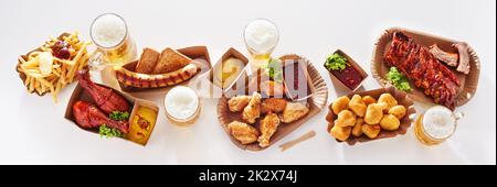Gläser Bier und verschiedene Snacks auf dem Tisch Stockfoto