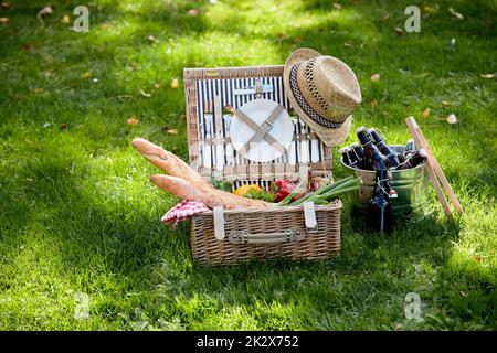 Picknickkorb mit Baguettes und Gemüse auf dem Rasen Stockfoto