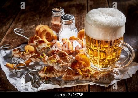 Ein Glas kaltes Bier mit Snacks auf dem Tisch Stockfoto