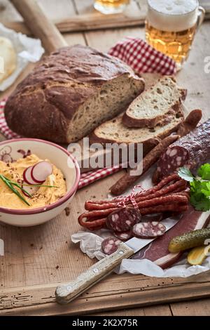 Köstliche Würstchen in der Nähe von Hummus und Brot Stockfoto