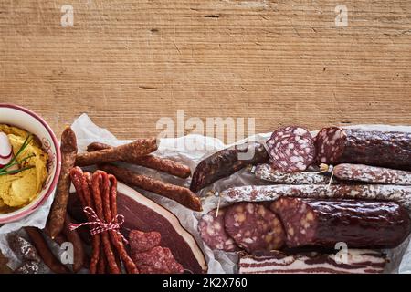 Verschiedene Würstchen auf einem Holztisch Stockfoto