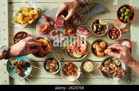 Nicht wiedererkennbare Leute, die verschiedene Snacks essen Stockfoto