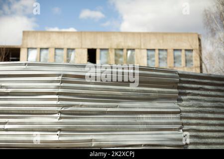 Stahlzaun und verlassenes Gebäude. Details des Ghettos. Stockfoto