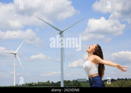 Aufgeregte Frau, die in einem Windpark schreit Stockfoto