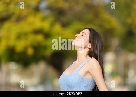 Entspannter Teenager, der in einem Park frische Luft atmet Stockfoto