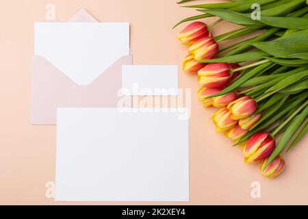 Weiße horizontale Karte und Bastelumschläge Mockup mit Blumenstrauß Stockfoto