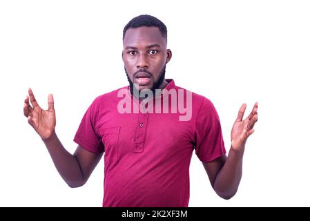 Porträt eines gut aussehenden, überraschten jungen Mannes mit rotem T-Shirt und gestikulierenden Händen, während er die Kamera betrat. Stockfoto
