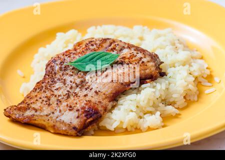 Weißer Fisch auf Kreuzkümmel, serviert mit Reis Stockfoto