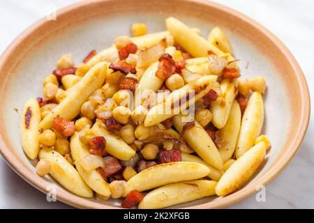 Schupfnudel mit Speck, Zwiebeln und Kichererbsen Stockfoto