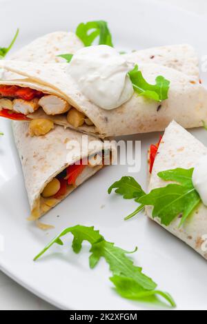 Tortilla gefüllt mit Hühnerfleisch, rotem Pfeffer und Bohnen Stockfoto