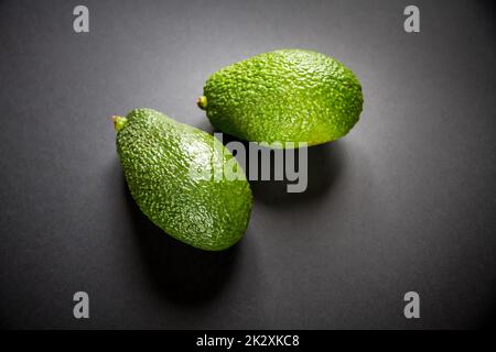 Zwei Avocados isoliert auf schwarzem Hintergrund Stockfoto