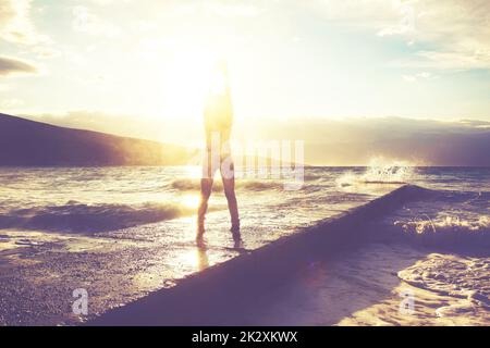 Große Wellen, die am Steinsteg bei stürmischem Wetter zerbrechen. Stockfoto