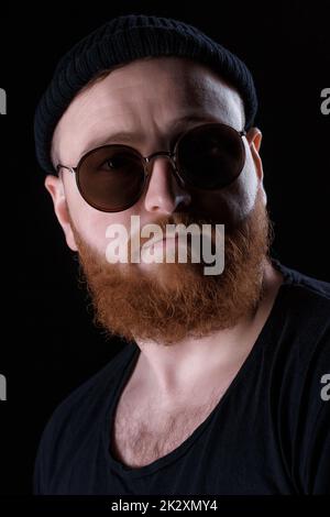 Bärtiger Mann mit Sonnenbrille und Hut Stockfoto