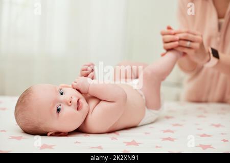 Mutter oder Therapeut, die ihr Kind zu Hause massiert Stockfoto