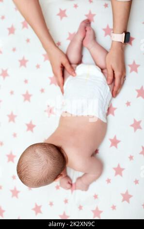 Babymassage. Mutter massierte ihr neugeborenes Baby. Stockfoto