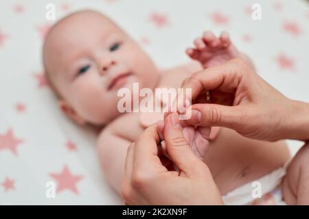 Massage der Babyhand von der Mutter, Nahaufnahme Stockfoto