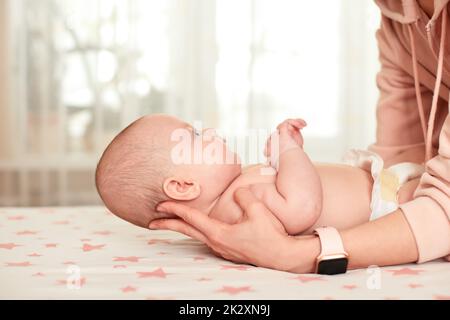 Babymassage. Mutter massierte ihr neugeborenes Baby. Stockfoto