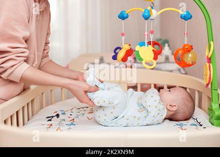 Babymassage. Mutter macht Gymnastik mit neugeborenem Kind Stockfoto