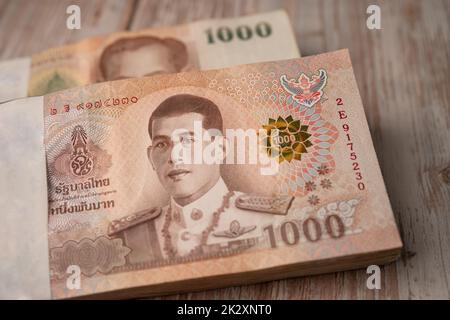 Stapel von Thai Baht Banknoten auf Holzhintergrund, Business-Sparen Finanzierung Investitionskonzept. Stockfoto