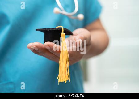 Asiatische Arzt Studie lernen mit Abschluss GAP Hut in Krankenhausstation, clever hell Genie Bildung Medizin Konzept. Stockfoto