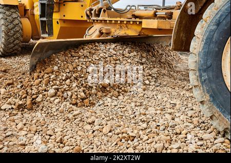 Das Grader-Blatt ebbt den Schutt auf der Baustelle Stockfoto