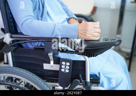 Asiatische ältere Frau Behinderung Patient sitzt auf elektrischen Rollstuhl im Park, medizinisches Konzept. Stockfoto