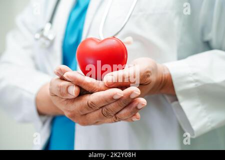 Asiatische Frau Arzt hält rotes Herz für die Gesundheit im Krankenhaus. Stockfoto