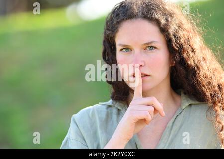 Eine ernste Frau, die im Park um Ruhe bittet Stockfoto