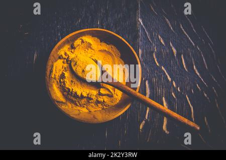 Indisches Kurkuma-Pulver, Kurkuma-Gewürz in einer kleinen Schüssel mit Löffel, Haldi-Pulver Stockfoto