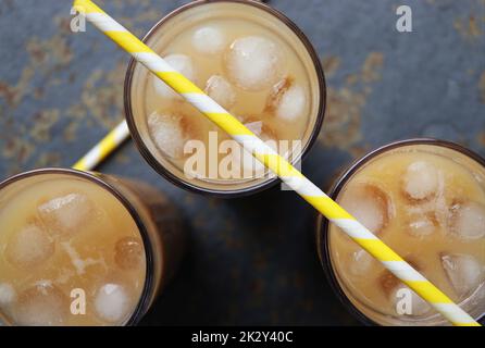 Sommergetränk Eiskaffee in hohem Glas auf rustikalem Holzhintergrund. Selektiver Fokus, Draufsicht Stockfoto