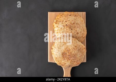 Draufsicht auf flaches Pita-Brot auf dunklem Hintergrund mit Kopierfläche Stockfoto