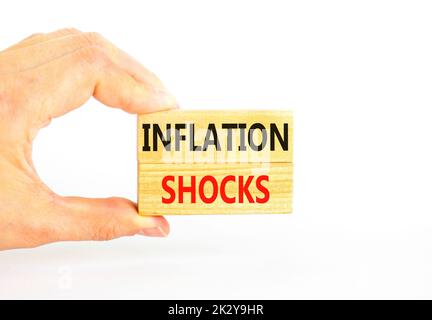 Symbol für Inflationsschocks. Konzept Worte Inflation Schocks auf Holzblöcke. Schöne weiße Tabelle weißen Hintergrund. Geschäftsmann Hand. Unternehmensinflation Stockfoto