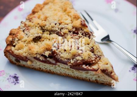 Plum-Crumble-Kuchen auf weißem Teller Stockfoto