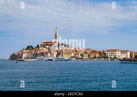 Der Blick auf den Fischereihafen Rovinj mit farbenfroher Architektur und kleinen Schiffen, die auf dem Wasser treiben, Kroatien Stockfoto
